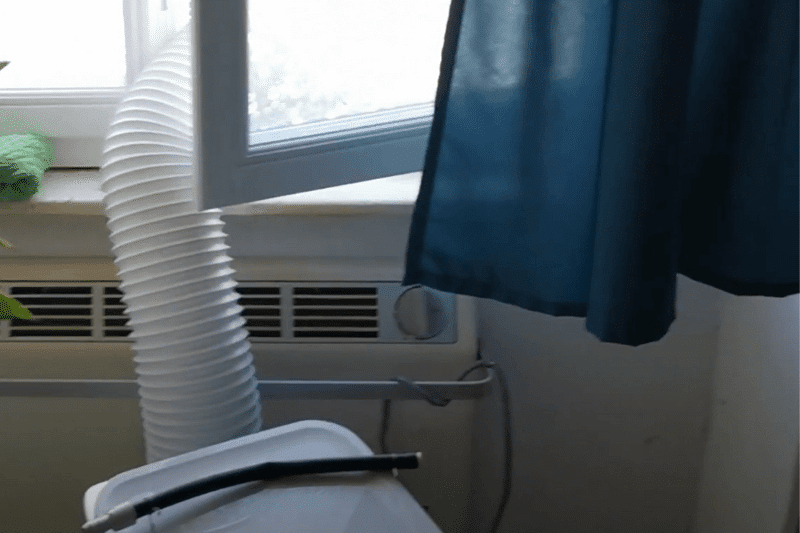 Der Abluftschlauch wird aus dem Fenster gehängt